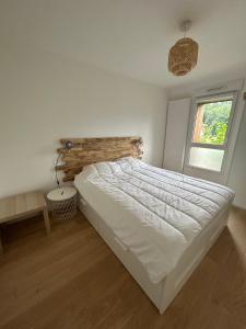 a bedroom with a white bed and a window at Appartement Samoens l'Etelley in Samoëns