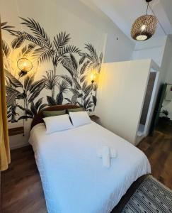 a bedroom with a white bed with a plant wall at Luxueux appartement cosy, hypercentre Castres in Castres +20 photos