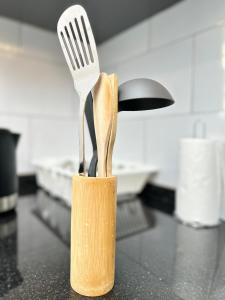 Un cuchillo y un tenedor en un bloque de cuchillos sobre un mostrador en LivLux Apartments 4, en Kampala
