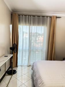 Un dormitorio con una cama y una ventana grande. en LivLux Apartments 4, en Kampala