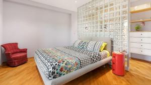 a bedroom with a bed and a red chair at VILLA TIBERIO 6&2, Emma Villas in Genzano di Roma +40 photos