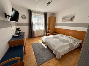 a bedroom with a bed and a television in it at Pension Stral-Sund UG in Stralsund