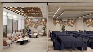a meeting room with blue tables and people sitting in chairs at Laxston Hotel in Yogyakarta