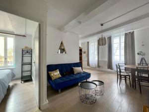 a living room with a blue couch and a table at Fun x Cosy City Retreat by Melrose in Bayeux