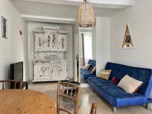 a living room with a blue couch and a table at Fun x Cosy City Retreat by Melrose in Bayeux