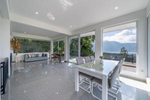 a dining room with a table and chairs and windows at Adara Lake View Residence Bedugul - Bali in Bedugul