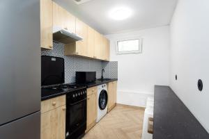 a kitchen with a stove and a dishwasher at Najtańsze noclegi Piłsudskiego 93 in Łódź
