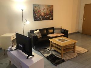 a living room with a couch and a table with a tv at Moderne Vollmöblierte Wohnung in Zwickau