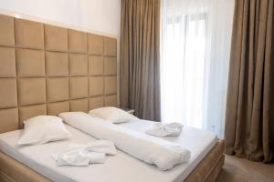 a bed with white sheets and towels on it at Vila Roxana Eforie Nord in Eforie Nord