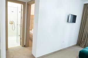 a room with a white wall with a tv on it at Vila Roxana Eforie Nord in Eforie Nord +13 photos