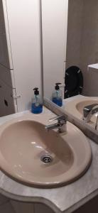 un lavabo con dos botellas de jabón. en PISO VINTAGE EN Madrid, en Móstoles