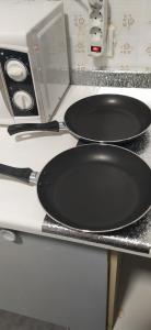 two pans are sitting on top of a stove at PISO VINTAGE EN Madrid in Móstoles