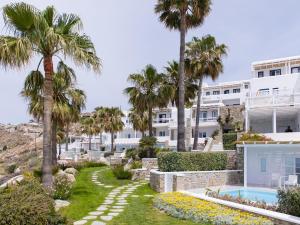 a resort with palm trees and a swimming pool at Mykonos Blu, A Grecotel Resort to Live in Psarou