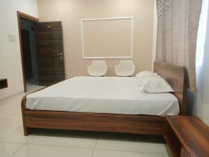 a bedroom with a bed with two chairs next to a window at Vaatsaly home's Rooms in Indore
