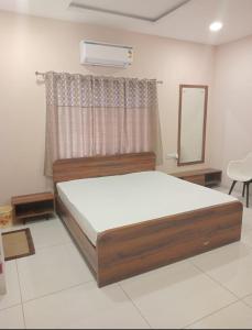 a bedroom with a large bed and a mirror at Vaatsaly home's Rooms in Indore