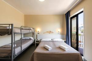dwa łóżka w pokoju z oknem w obiekcie Hotel La Siesta w mieście Lido di Jesolo