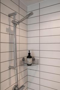 a shower with a bottle of soap on a glass shelf at The Pier Penthouse by Daniel&Jacob's in Copenhagen