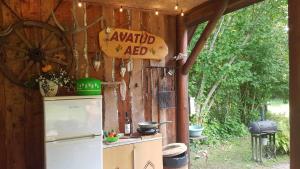 a kitchen with a refrigerator and a sign on the wall at Lonni Nature Eco-Accommodation in Hagudi