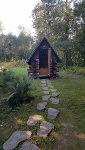 a small log cabin with a door in the grass at Lonni Nature Eco-Accommodation in Hagudi