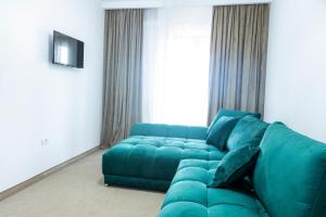 a living room with a blue couch in front of a window at Vila Roxana Eforie Nord in Eforie Nord