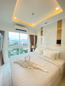 a bedroom with a large white bed with a large window at Empire Tower Pattaya Jomtien Beach in Jomtien Beach