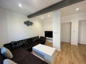 ein Wohnzimmer mit Couch und Tisch in der Unterkunft T2 rénové à 15 min de Lyon in Pierre-Bénite