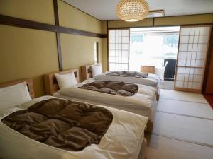 Rúm í herbergi á 桜 River Side Stay下呂温泉