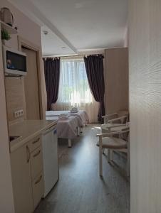a room with a kitchen and a room with a bed at Київські Ночі in Kyiv