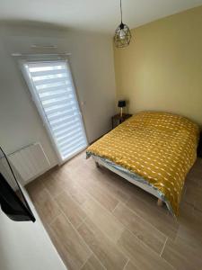 a bedroom with a bed and a large window at Maison à 300m de la mer avec 2 chambres in Lion-sur-Mer