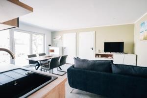 a living room with a couch and a table at Ferienhaus Küstennebel - Ostseewelle mit Sauna in Ostseebad Koserow