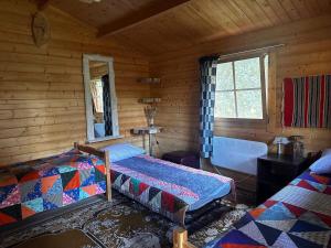 a bedroom with two beds in a log cabin at Tammispea puhkeküla in Tammispea
