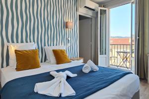 une chambre avec un lit avec des serviettes dessus dans l'établissement Aparthotel AMMI Nice Massena - ex Ajoupa, à Nice