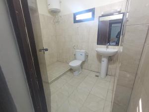 a bathroom with a toilet and a sink at Mamy Residence in Nouakchott +19 photos