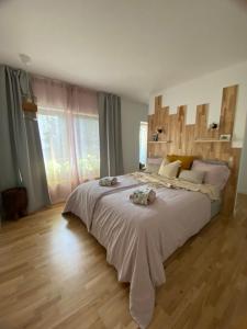 una camera da letto con un letto grande con testiera in legno di Nook. The Design Apartment a Târgu-Mureş