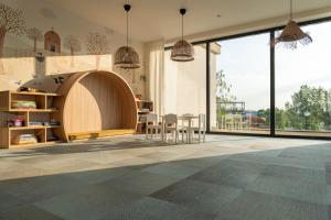 a room with a table and chairs and large windows at Thermal Hotel Campino in Dunajská Streda