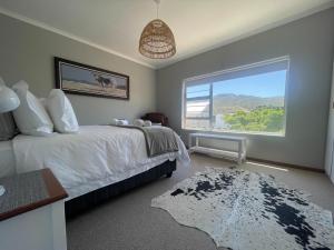 a bedroom with a bed and a large window at Footprints in Kleinmond in Kleinmond +26 photos