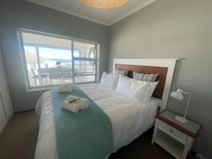 a bedroom with a bed with two towels on it at Footprints in Kleinmond in Kleinmond