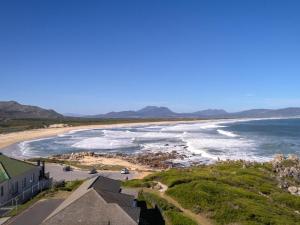 an aerial view of a beach with mountains in the distance at Footprints in Kleinmond in Kleinmond