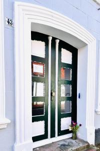 a front door of a house with a green door at Apartments-am-Wellenreiter-Kuestenstudio in Tating