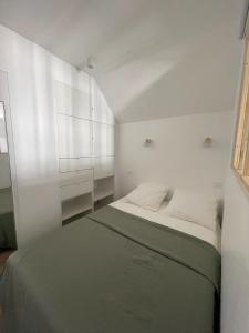 een witte slaapkamer met een bed en witte kasten bij New fully equiped appartment with parking in Saint-Mandé