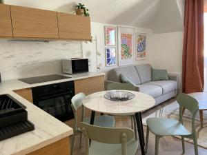 a kitchen and living room with a table and a couch at New fully equiped appartment with parking in Saint-Mandé
