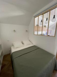een kleine slaapkamer met een bed en een raam bij New fully equiped appartment with parking in Saint-Mandé