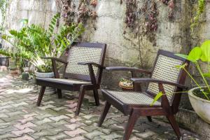 two chairs sitting on a stone patio with plants at Lakmali Homestay in Watagederamulla +14 photos