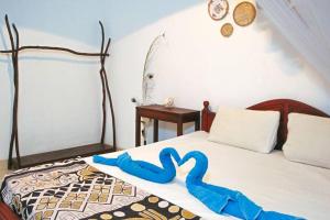 a bedroom with a bed with a pair of towels on it at Lakmali Homestay in Watagederamulla