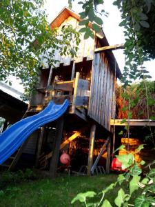 a tree house with a slide and a playground at Ferienzimmer KAI mit Fahrradverleih in Zinnowitz