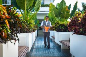 a man walking through a greenhouse with plants at Viroth's Hotel in Siem Reap