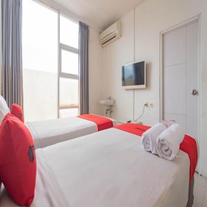 a hotel room with two beds and a tv at RedDoorz near Trans Studio Mall Bongo Residence in Bandung