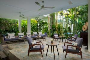 a patio with chairs and tables and trees at Viroth's Hotel in Siem Reap