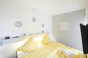 a bedroom with a bed with yellow and white pillows at NEU! Fernblick Hohegeiß Sauna Hallenbad in Hohegeiß +35 photos