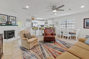 un soggiorno con un divano, sedie e un tavolo di D Cottage Lillian a Lillian